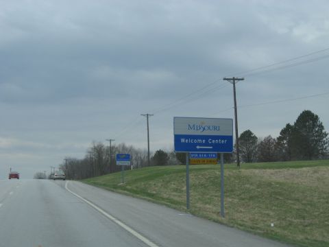 1978 Ford Bronco - A sign indicates the Missouri Welcome Center is ahead, with operating hours posted below.