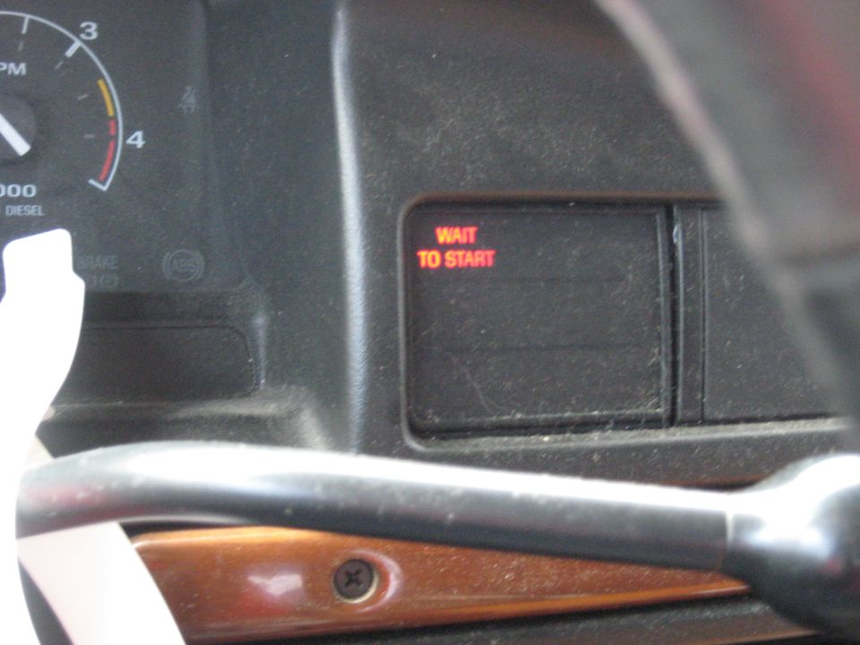 Dashboard interior with tachometer and red "WAIT TO START" indicator light