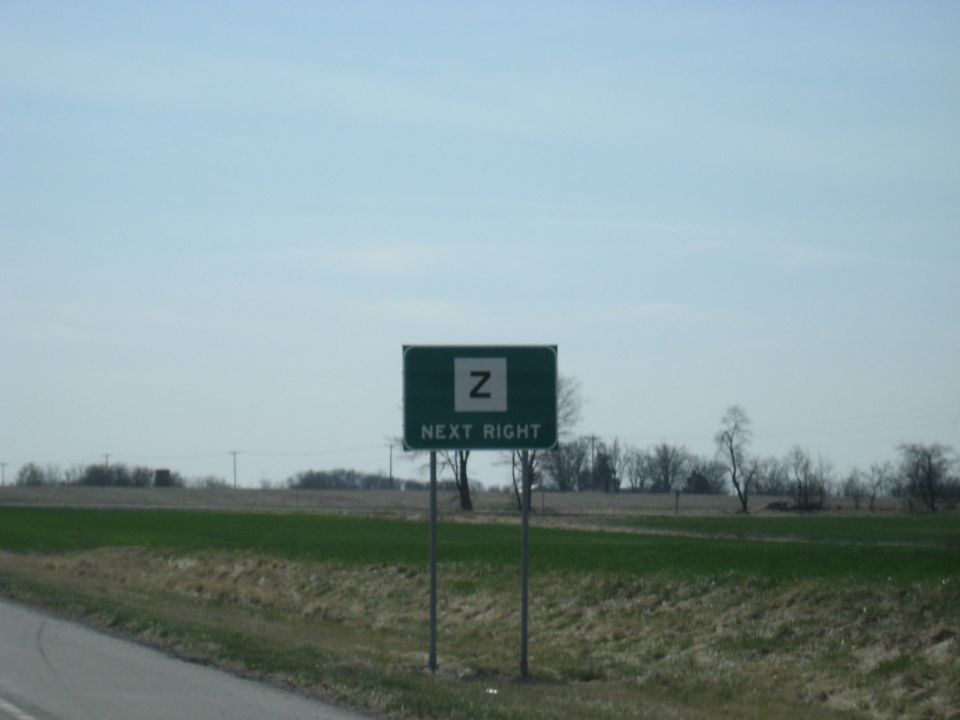 Green highway sign with a white 'Z' and 'NEXT RIGHT' text
