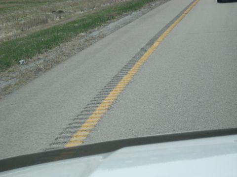 1978 Ford Bronco - Driving on a highway with a yellow line and rumble strip marking the lane.