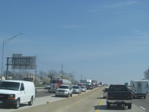 1978 Ford Bronco - A long line of vehicles is stuck in traffic on a sunny day.