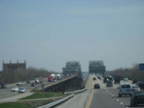 1978 Ford Bronco - Multiple vehicles travel on a highway bridge under a hazy sky.