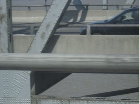 1978 Ford Bronco - A black SUV is seen from the side while driving on a bridge.