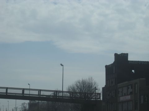 1978 Ford Bronco - An overpass and industrial buildings are visible under a cloudy sky.