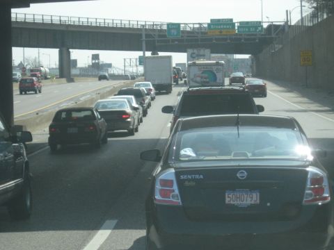 1978 Ford Bronco - A highway scene shows a traffic jam with cars and trucks in multiple lanes under an overpass.