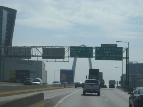 1978 Ford Bronco - Driving on a highway with multiple vehicles and directional signs, the St. Louis Arch is visible.