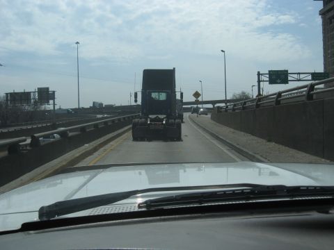 1978 Ford Bronco - Driving behind a semi-truck on a highway with overpasses and signs.
