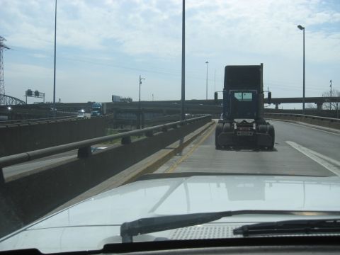 1978 Ford Bronco - View from a white pickup truck driving on a highway, with a semi-truck ahead.