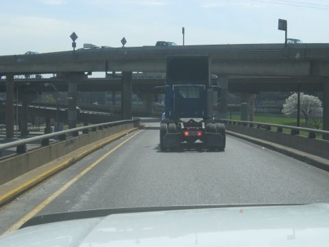 1978 Ford Bronco - A blue semi-truck cab is seen from behind while driving on an elevated highway.