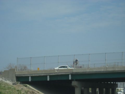 1978 Ford Bronco - A white sedan travels along an elevated highway on a bright, clear day.