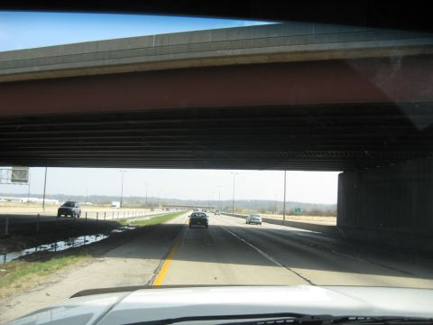 1978 Ford Bronco - Cars travel on a highway beneath a concrete overpass on a clear day.