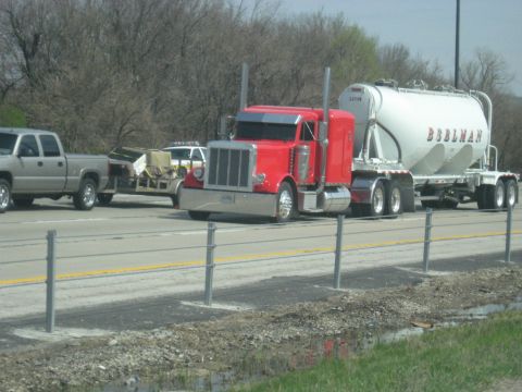 1978 Ford Bronco - Multiple vehicles including a red semi-truck and a silver pickup truck travel on a highway.