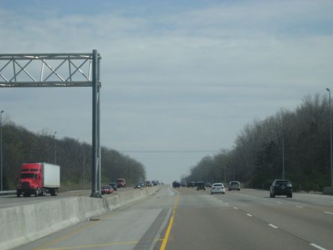 1978 Ford Bronco - Vehicles travel on a highway under a cloudy sky, with trees lining the sides of the road.