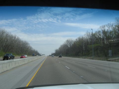 1978 Ford Bronco - A view from a vehicle traveling on a highway with trees lining the sides and other cars on the road.