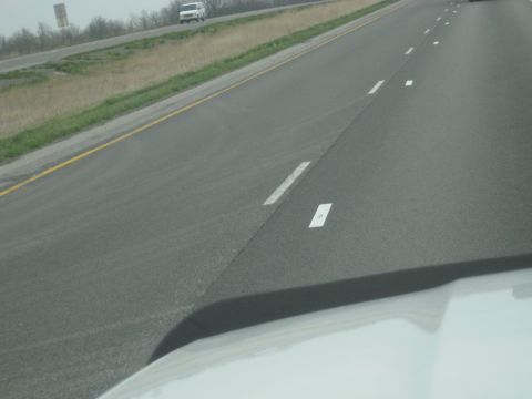 1978 Ford Bronco - A white van travels down a highway, seen from the perspective of another vehicle on the road.