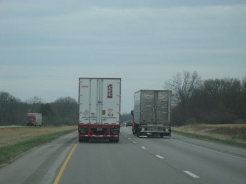 1978 Ford Bronco - Two semi-trailer trucks are traveling down a highway under an overcast sky.
