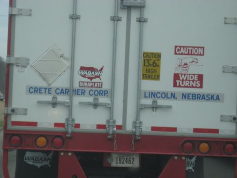 1978 Ford Bronco - The rear of a trailer displays company information and caution signs.