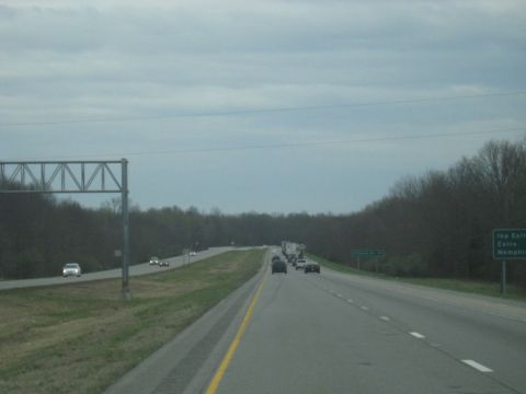 1978 Ford Bronco - Driving on a highway with traffic under a cloudy sky. Roadside trees are visible.