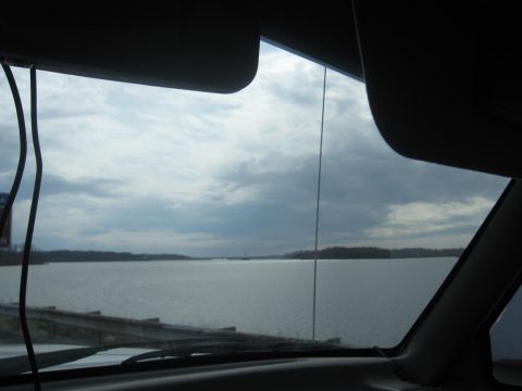 1978 Ford Bronco - Looking out from the car's interior at a vast expanse of water under a dramatic, cloudy sky.