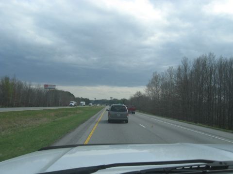1978 Ford Bronco - Vehicles travel down a highway with trees and a billboard visible on the side.