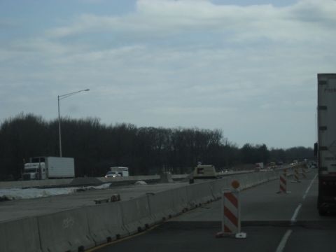 1978 Ford Bronco - A highway construction zone is visible with concrete barriers and traffic cones lining the road.