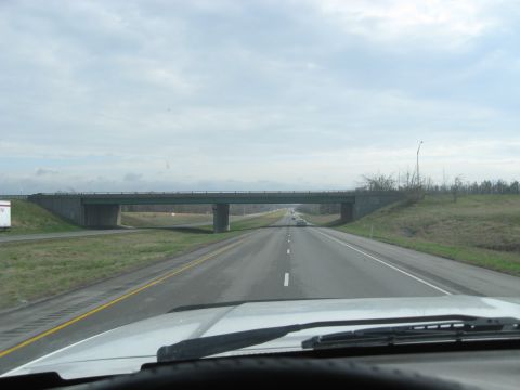 1978 Ford Bronco - Driving down the highway under a cloudy sky, approaching an overpass.