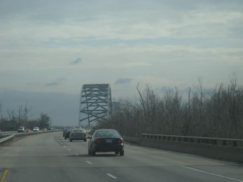 1978 Ford Bronco - Driving on a highway towards a large metal truss bridge with other vehicles on the road.
