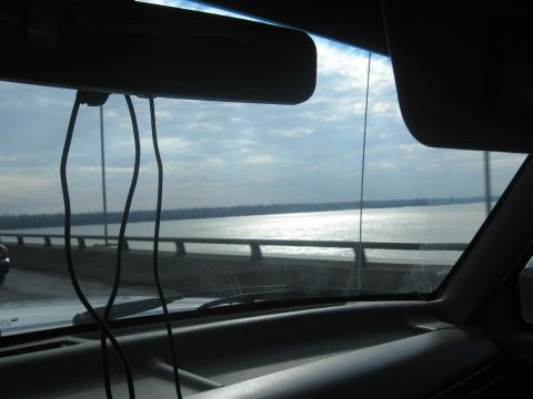 1978 Ford Bronco - Driving across a bridge over a wide river on a cloudy day.