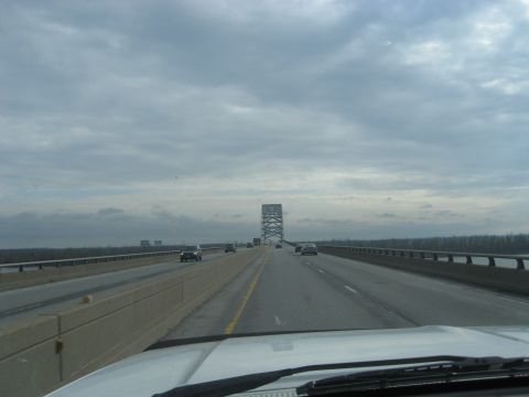 1978 Ford Bronco - Driving across a bridge on a cloudy day, with other vehicles visible on the roadway.