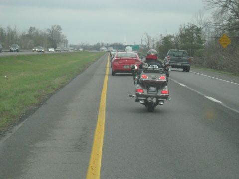1978 Ford Bronco - A motorcycle travels down a highway on an overcast day, with other vehicles in its vicinity.