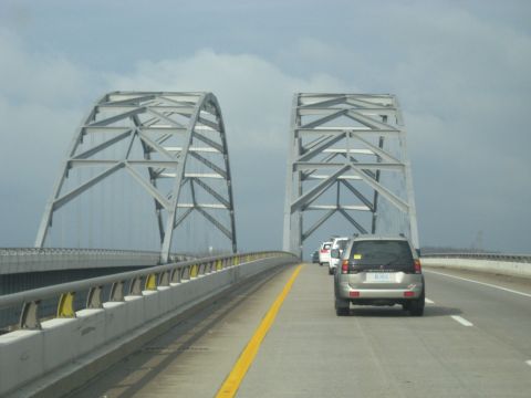 1978 Ford Bronco - Vehicles travel across a large bridge under a cloudy sky.