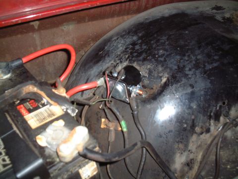1967 Ford Galaxie - Close-up view of a starter solenoid and battery with red cables connected.