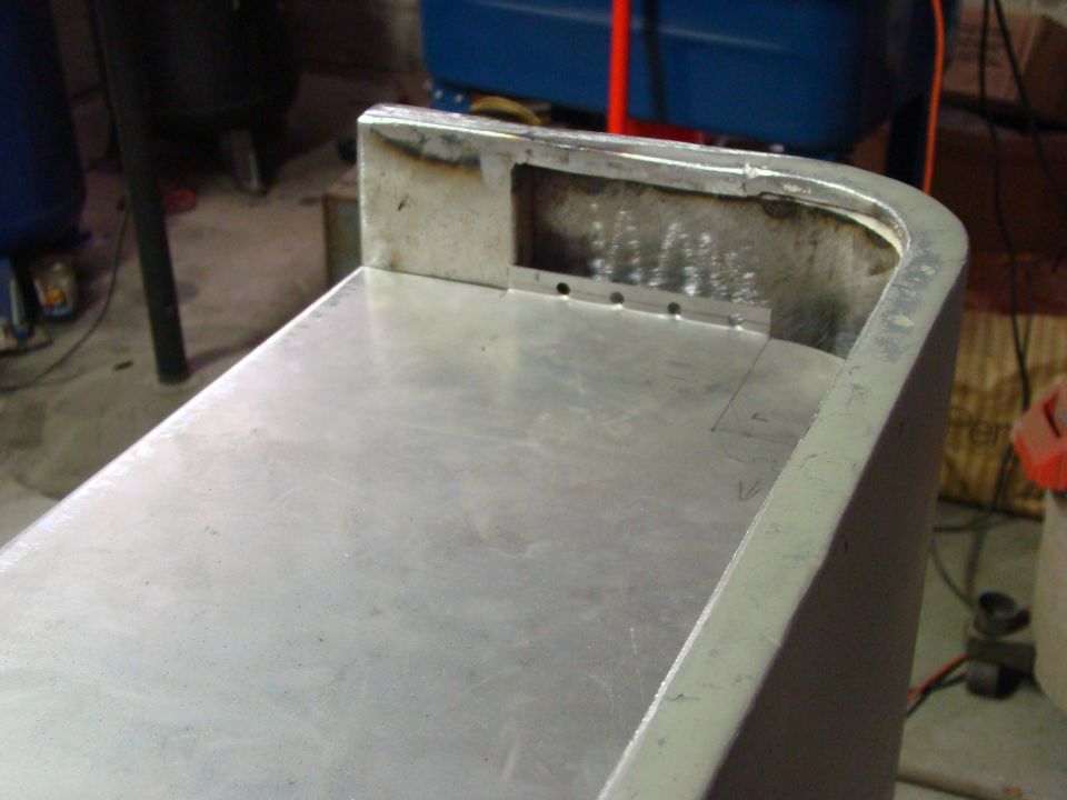 Aluminum panel with welded edges and drilled holes, showing signs of fabrication