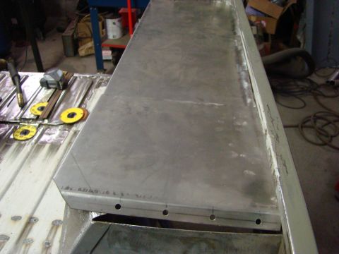 1948 Jeep Wrangler - A close-up view of metal fabrication work in progress, showing a large sheet of metal and tools.