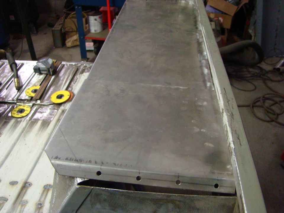 metal sheet being worked on with tape measure and welding torch nearby