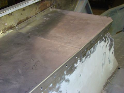 1948 Jeep Wrangler - A metal panel, likely a repair or modification, is screwed onto a vehicle's interior structure.