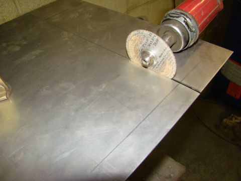 1948 Jeep Wrangler - A grinding disc is positioned to cut a metal sheet, with visible cut lines and a red tool handle.