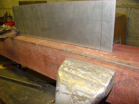 1948 Jeep Wrangler - A metal part is marked with scribe lines and clamped to a workbench for fabrication.