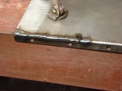 1948 Jeep Wrangler - Close-up of a metal panel being welded, showing the weld beads and pre-drilled holes.