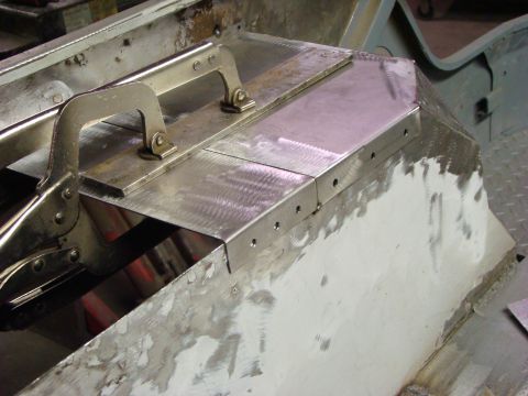 1948 Jeep Wrangler - Close-up of metalwork being done on a vehicle's chassis, with clamps holding panels in place.