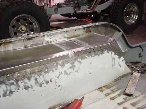 1948 Jeep Wrangler - A vehicle frame and tire are visible during a repair process, with metalwork being done on the frame.