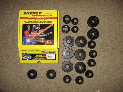 1979 Ford Bronco - A collection of polyurethane bushings and their packaging are laid out on a textured surface.