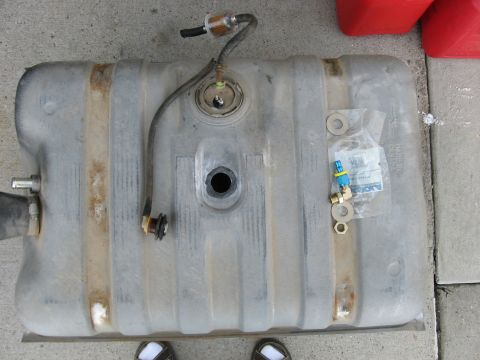 1979 Ford Bronco - Fuel tank assembly, including a fuel filter and various brass fittings, laid out on a concrete surface.
