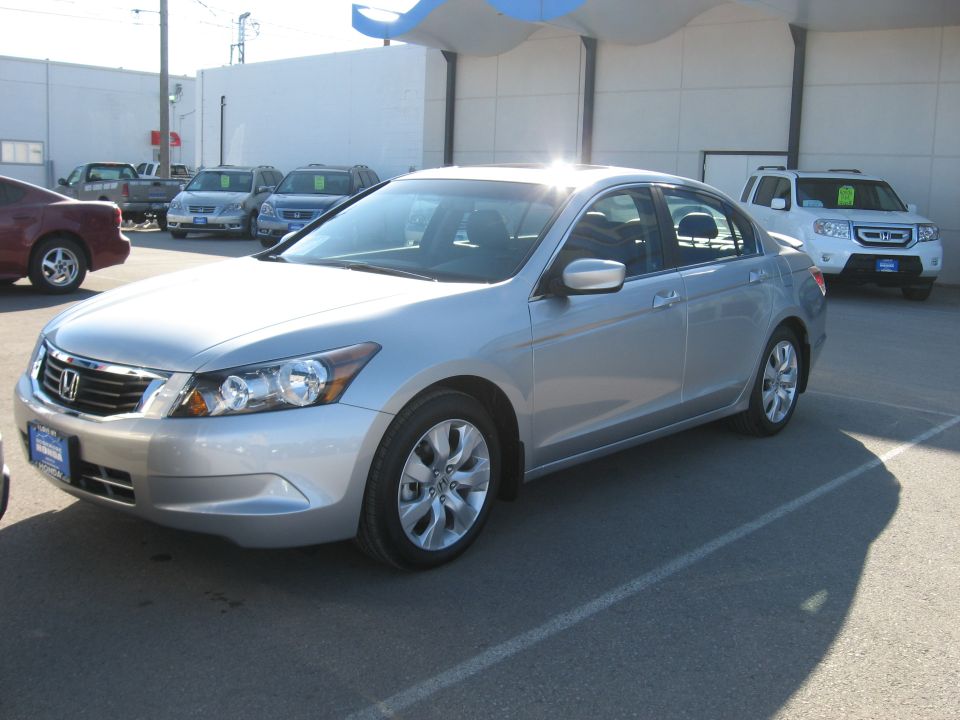 Silver sedan parked in a lot with other cars visible