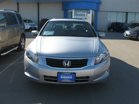2009 Honda Accord - A silver sedan is parked in front of a dealership with other vehicles visible in the background.