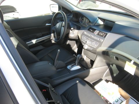 2009 Honda Accord - The interior of a car, black leather seats and a modern dashboard with a prominent infotainment system.