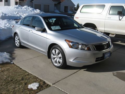 2009 Honda Accord - This silver 2009 Honda Accord is parked in a driveway next to a white SUV, with snow visible in the background.