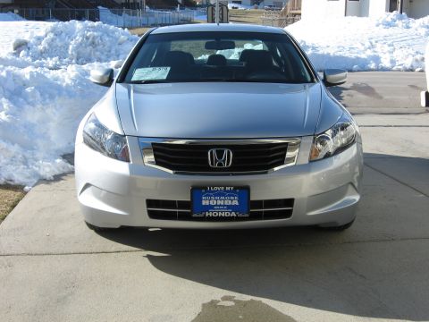 2009 Honda Accord - Front view of a silver sedan with a dealership license plate frame. Snow is visible on the sides.