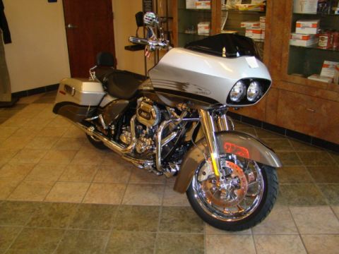 2009 Harley-Davidson FLH - A silver 2009 Harley-Davidson FLH motorcycle is parked indoors, its detailed engine and chrome components.