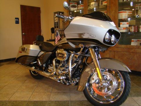 2009 Harley-Davidson FLH - A Harley-Davidson motorcycle with a large fairing and saddlebags is displayed indoors.